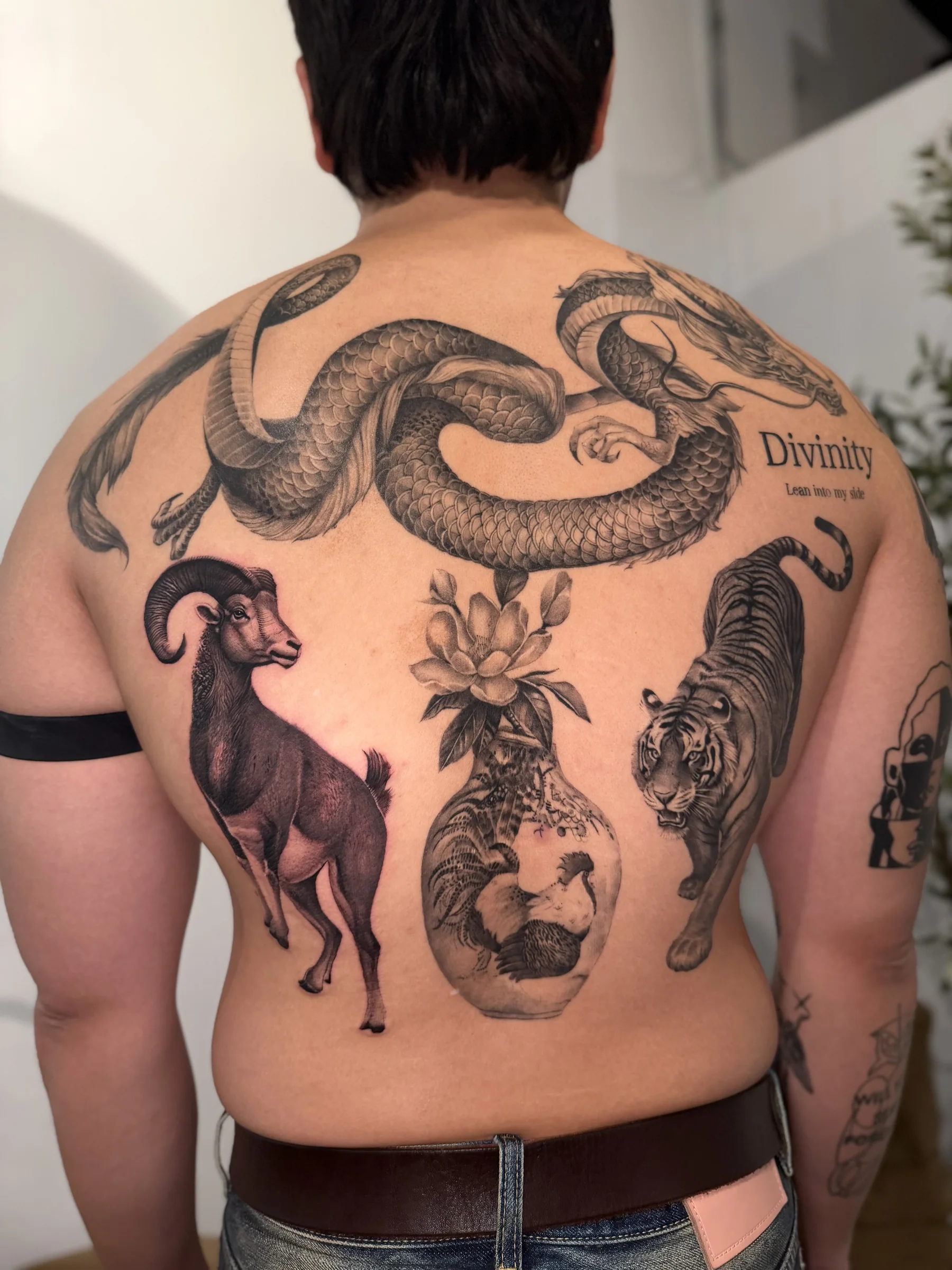 Full back piece with a ram, a tiger, a snake and the word Divinity