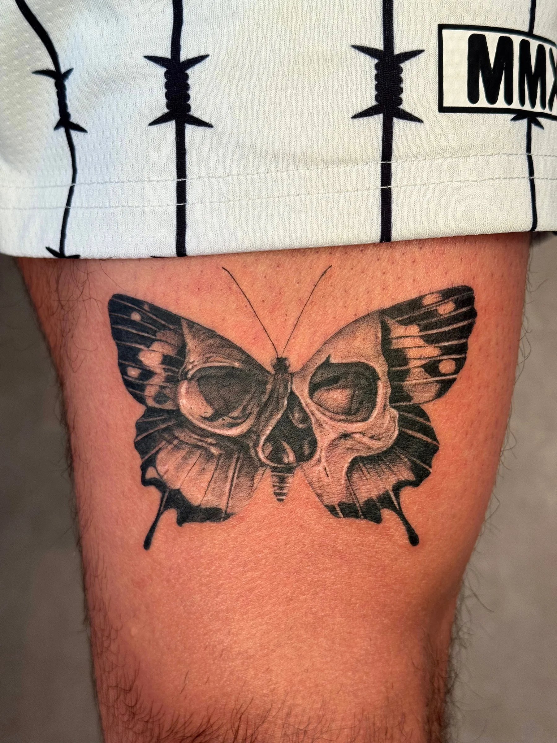 Butterfly with a skull pattern in its wings on an upper arm